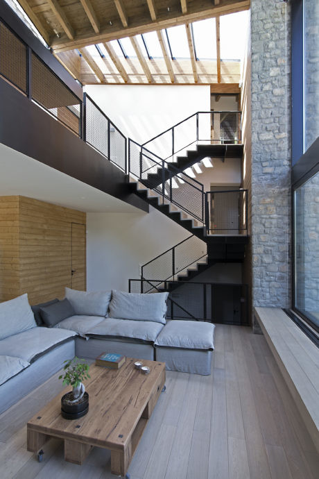 Modern interior with spiral staircase, high ceilings, and a mix of brick, wood