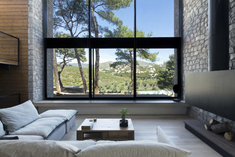 Contemporary living room with large window overlooking scenic landscape.