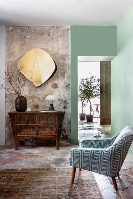 Eclectic interior with distressed wall, vintage furniture, and abstract art.