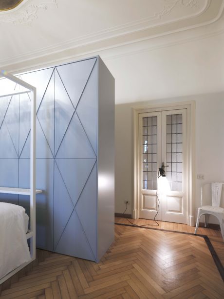 Contemporary blue wardrobe in a classic room with herringbone flooring.
