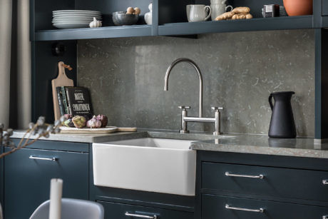 Modern kitchen with dark cabinets and white countertops.