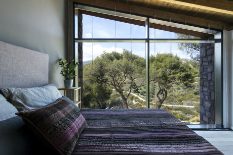 Modern bedroom with large window overlooking nature.