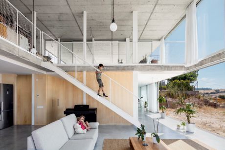Contemporary home interior with exposed concrete and open staircase design.