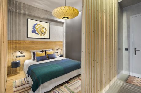 Modern bedroom with wooden accents and a pendant lamp.