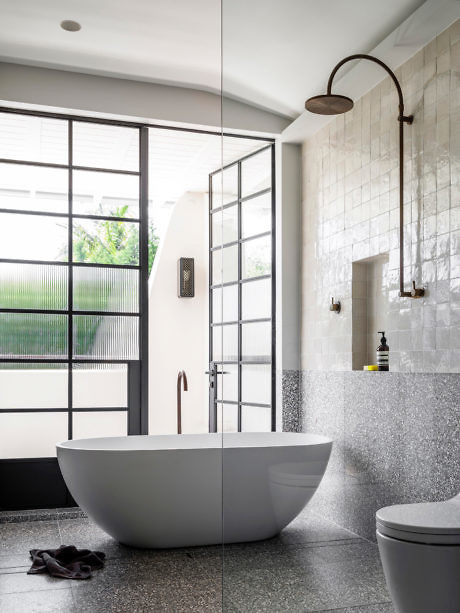 Modern bathroom with a freestanding tub, walk-in shower, and industrial accents