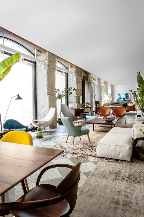 Modern living room with eclectic furniture and exposed concrete beams.