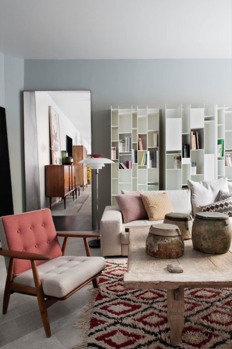 Modern living room with eclectic furniture and a bookshelf.