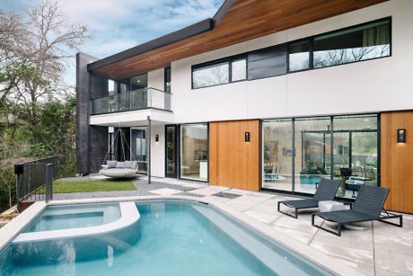 Modern two-story house with pool and patio area.