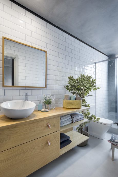 Modern bathroom with white subway tiles, wooden vanity, and glass shower.