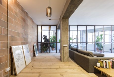 Modern hallway with wooden floors, brick walls, and minimalist decor.