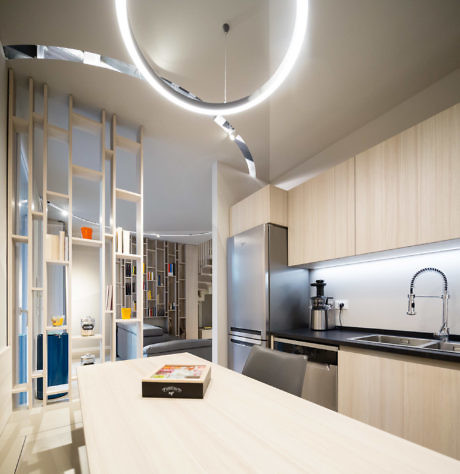 Modern kitchen interior with circular light fixture and open shelving.