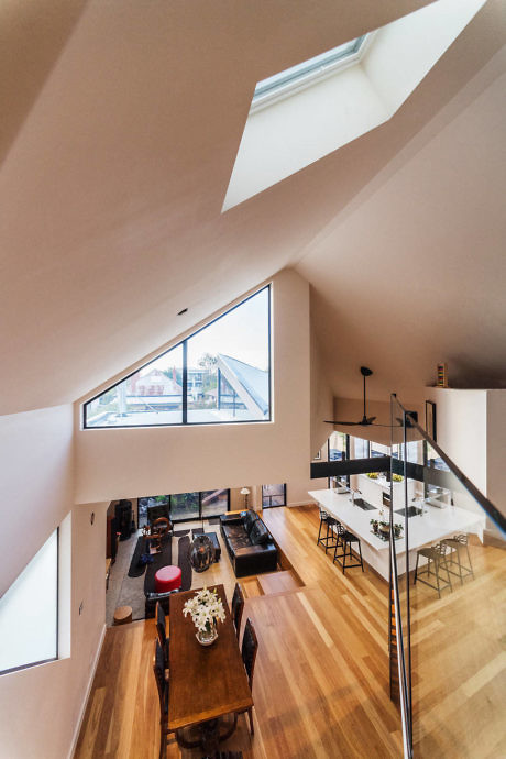 Contemporary loft interior with angled walls and skylights.