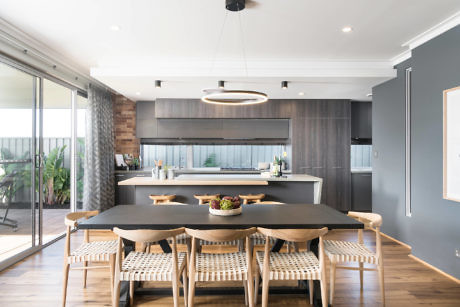Contemporary kitchen with wooden dining set and pendant lighting.
