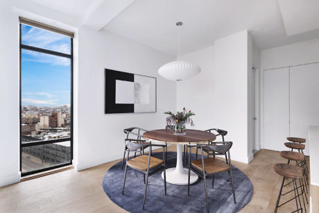 Contemporary dining room with city view, artistic light fixture, and round table.