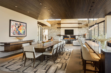Modern dining room with stone fireplace and elegant furnishings.