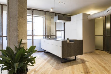 Contemporary kitchen with industrial elements and wood floors.
