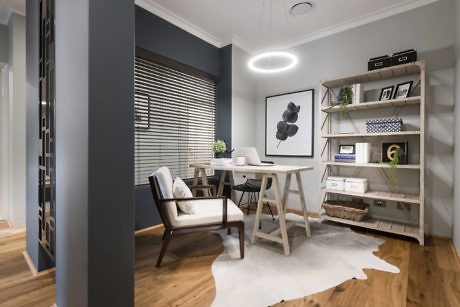 Modern home office with desk, chair, bookshelf, and decorative wall art.