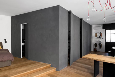 Contemporary interior with gray walls, wood floors, and red light fixtures.