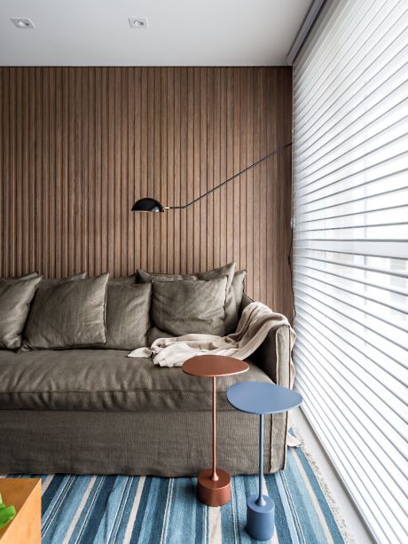 Contemporary living room with slatted wood walls, sofa, and minimalistic decor