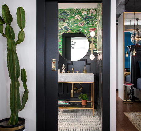 Eclectic entryway with botanical wallpaper, large cactus, and mid-century console