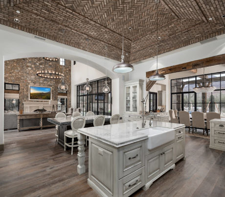Spacious kitchen with herringbone ceiling, stone accents, and central island.
