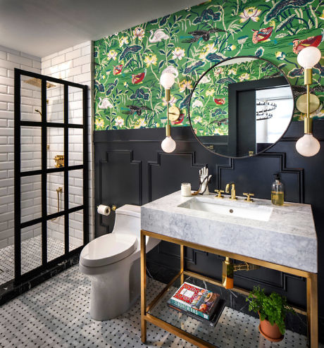 Eclectic bathroom with bold botanical wallpaper and marble vanity.