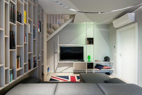 Sleek living space with wall-mounted bookshelves, under-stair storage