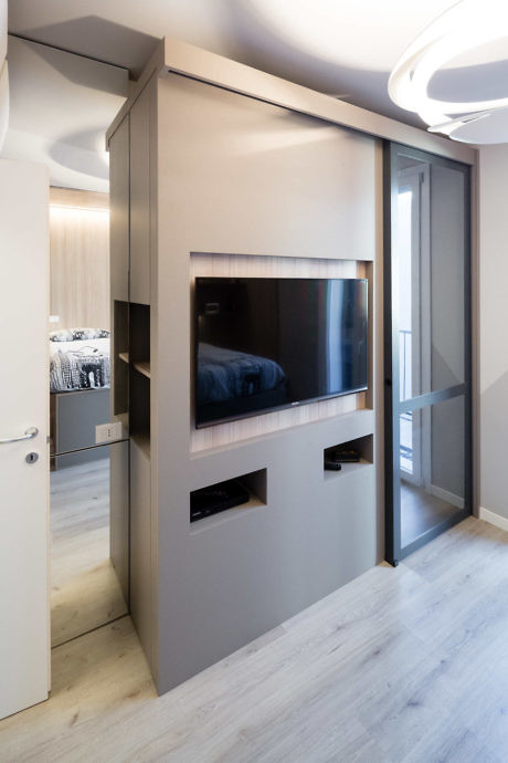 Modern room with wall-mounted TV, sliding door, and recessed lighting.