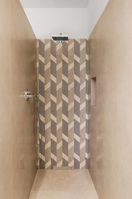Contemporary shower with chevron-patterned tiles and a neutral color palette.