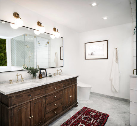 Elegant bathroom with dark wood vanity, marble floor, and traditional rug.