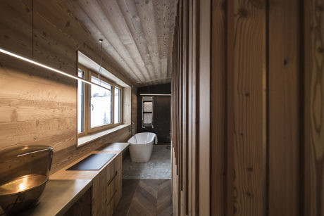 Contemporary wooden bathroom with sleek fixtures and ambient lighting.