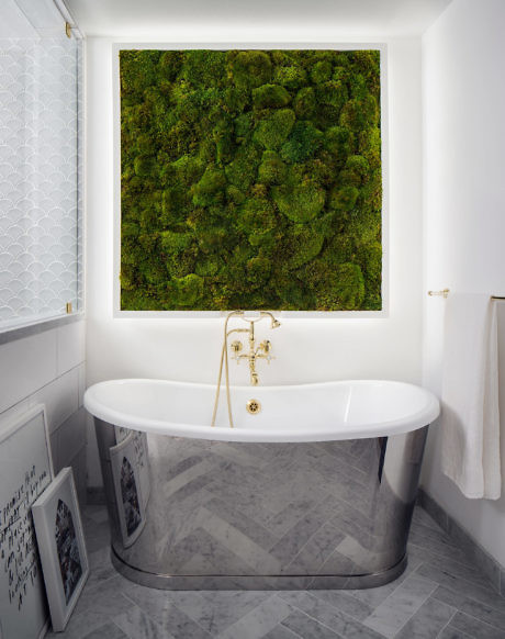 Elegant bathroom with a freestanding tub and a large moss art piece above