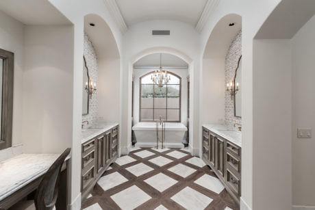 Elegant bathroom with arched alcoves and patterned floor.