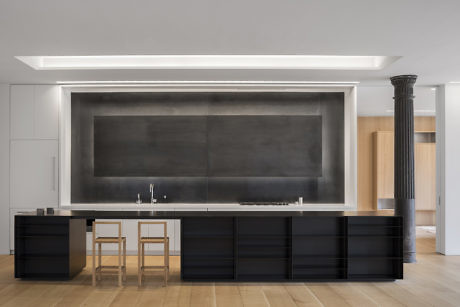 Modern kitchen with black cabinets and central island under a white ceiling with recessed lighting