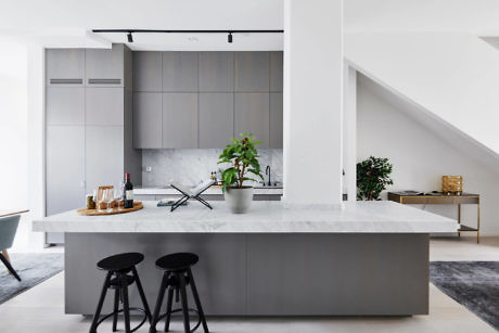 Modern kitchen interior with island and bar stools.