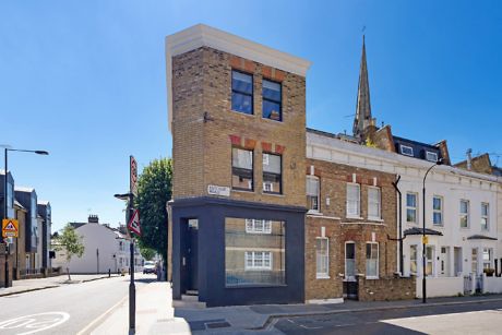Corner building with a mix of traditional brickwork and a sharp, cubic upper extension
