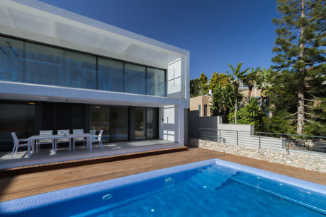 Modern house with pool and outdoor dining area.