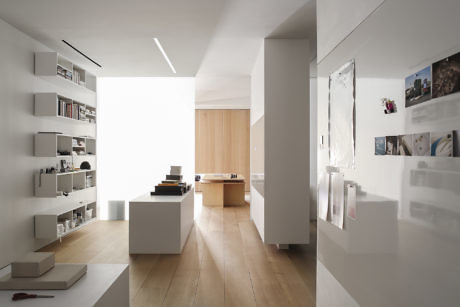Minimalist hallway with white walls, wooden floor, and built-in shelving.