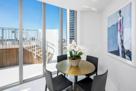 Modern dining area with table, chairs, and balcony access.
