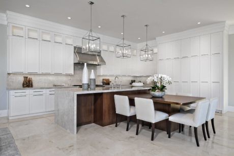 Elegant kitchen with white cabinetry, central island, and pendant lights.