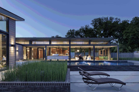 Contemporary house with poolside loungers at dusk.