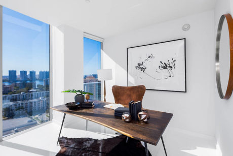 Chic interior with wooden desk, abstract art, and city view.