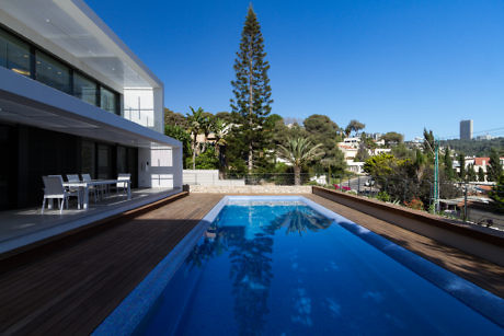 Contemporary house with pool, deck, and scenic view.