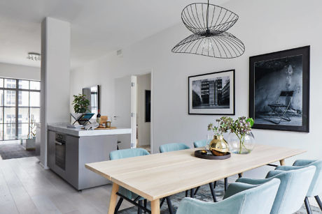 Contemporary open-plan living space with minimalist decor and large windows.