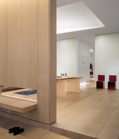 Minimalist interior with light wood panels and simple furniture.