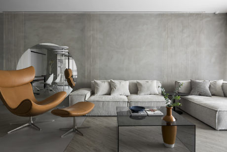 Modern living room with a tan lounge chair, gray sectional sofa, and neutral decor