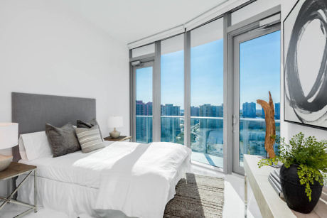 Modern bedroom with large windows and city view.