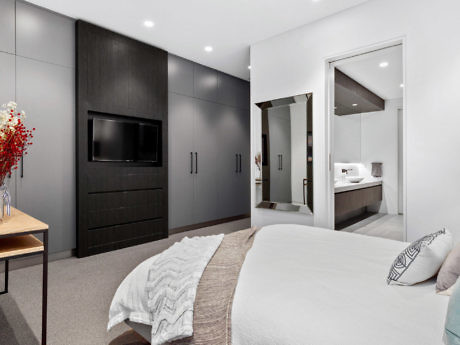 Contemporary bedroom with sleek dark cabinetry and en-suite entrance.