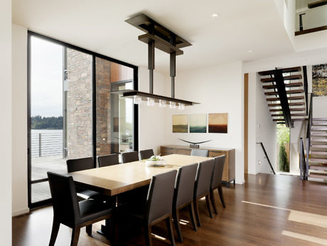 Contemporary dining space with large windows and a staircase.