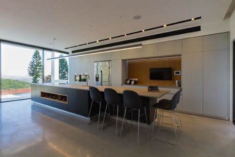 Sleek kitchen interior with bar stools and a panoramic view.